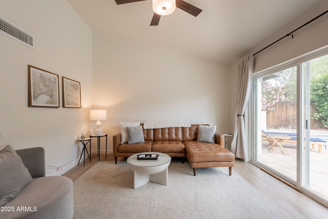 living area with wood finished floors, ceiling fan, and high vaulted ceiling