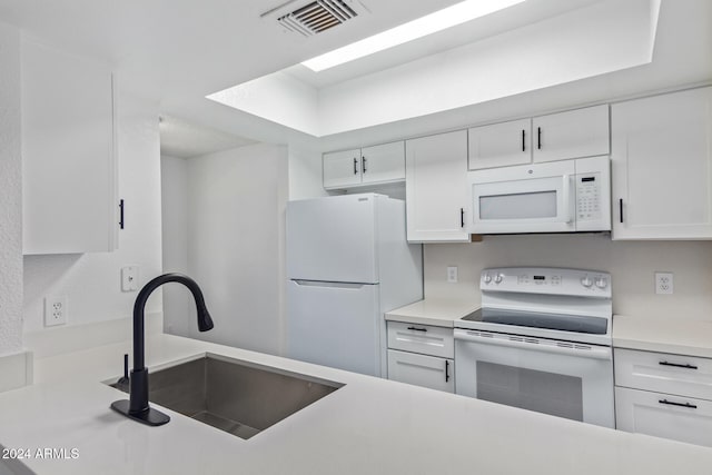 kitchen with sink, white appliances, and white cabinetry