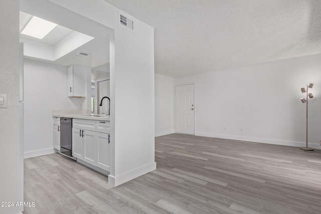 kitchen with dishwasher, light hardwood / wood-style flooring, sink, and white cabinetry