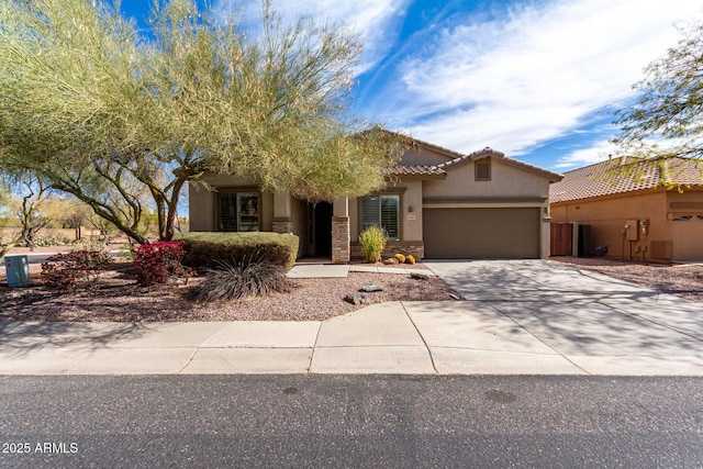 view of front facade featuring concrete driveway, a tile roof, an attached garage, and stucco siding