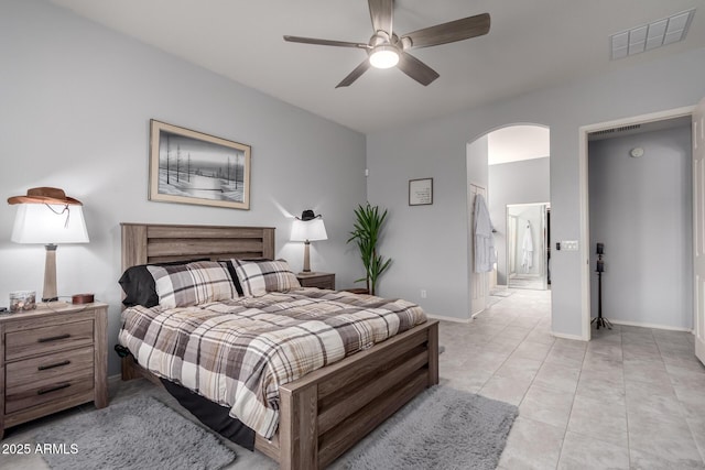 bedroom with arched walkways, light tile patterned floors, visible vents, and baseboards