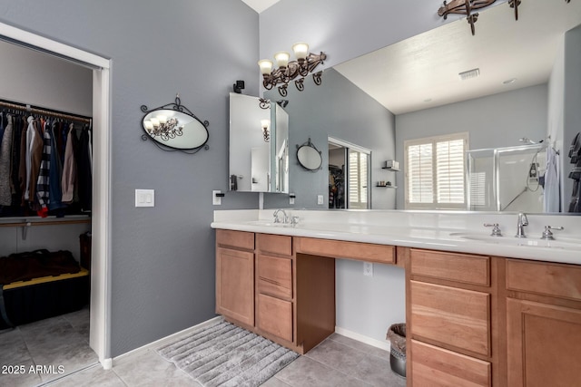 bathroom featuring double vanity, a shower stall, visible vents, and a sink