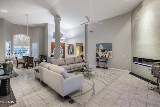 28897 N 94th Pl, Scottsdale, AZ 85262 - living room with a high ceiling, ceiling fan, a large fireplace, ornate columns, and baseboards