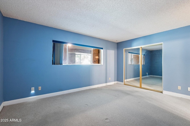 unfurnished bedroom with baseboards, carpet flooring, a closet, and a textured ceiling