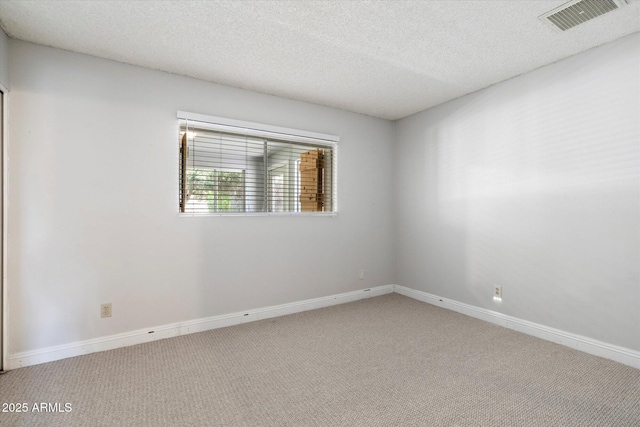 empty room featuring baseboards, visible vents, and carpet floors
