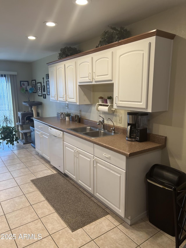 kitchen with white cabinetry, sink, light tile patterned floors, and dishwasher