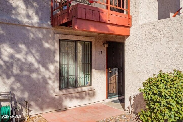 view of exterior entry with a balcony