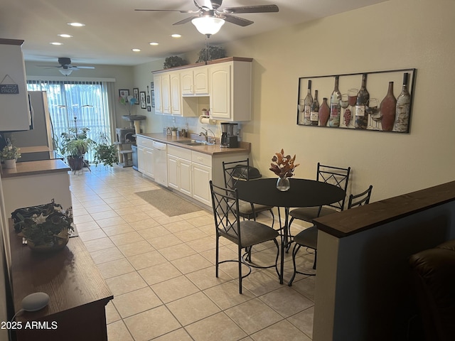 kitchen featuring light tile patterned flooring, sink, white cabinetry, dishwasher, and ceiling fan