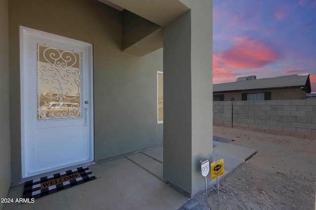 exterior entry at dusk with a patio area