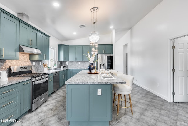 kitchen with a center island, stainless steel appliances, decorative backsplash, and light stone countertops