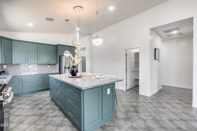 kitchen featuring stainless steel appliances, a center island, light tile patterned floors, and light stone counters