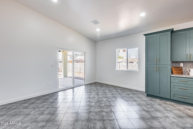 unfurnished dining area with light tile patterned floors, vaulted ceiling, and a healthy amount of sunlight