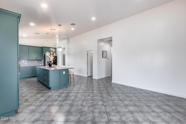 kitchen featuring decorative backsplash, a kitchen breakfast bar, pendant lighting, light tile patterned floors, and a center island