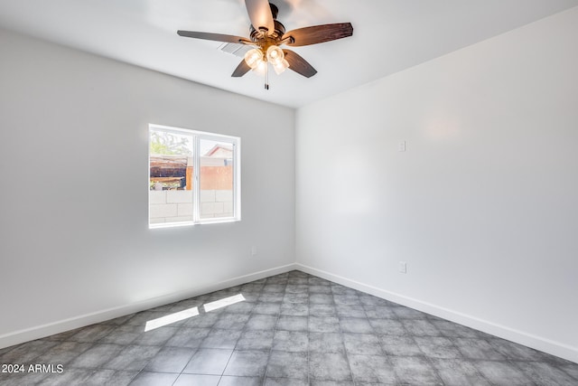 tiled spare room featuring ceiling fan