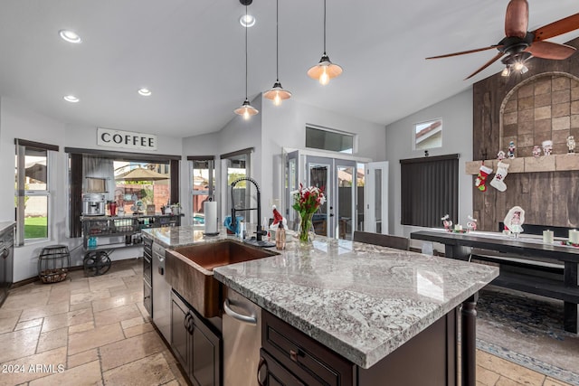 kitchen featuring french doors, sink, an island with sink, decorative light fixtures, and dark brown cabinetry