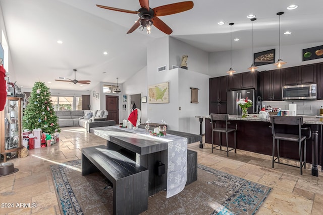 dining space featuring ceiling fan and high vaulted ceiling