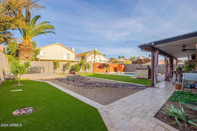 view of yard featuring ceiling fan and a patio area