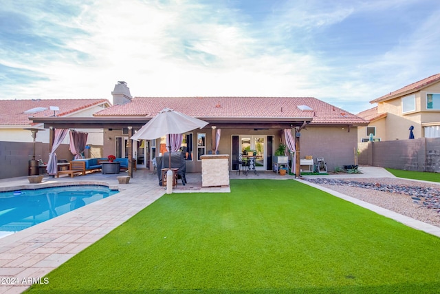 back of property with a lawn, an outdoor living space, a fenced in pool, ceiling fan, and a patio area