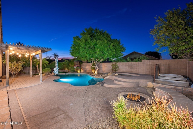 pool at night featuring a pergola, a patio area, and a fire pit