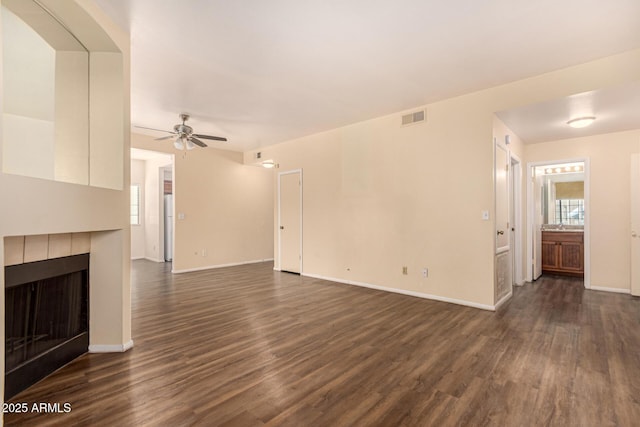 930 N Mesa Dr Unit 1023, Mesa, AZ 85201 - unfurnished living room with dark wood-style flooring, ceiling fan, and a tile fireplace