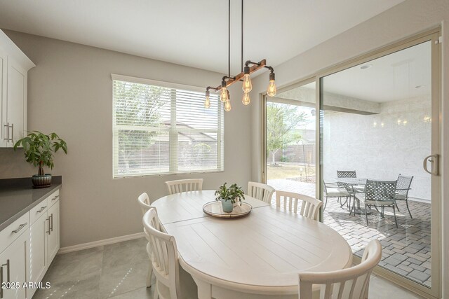 dining room with light tile patterned floors, baseboards, and plenty of natural light