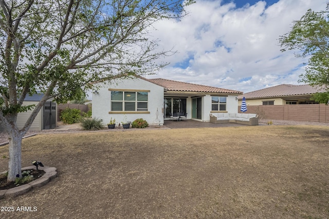 rear view of property featuring stucco siding, an outdoor hangout area, a storage shed, a fenced backyard, and an outdoor structure