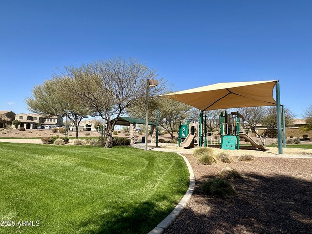 view of home's community featuring playground community and a yard