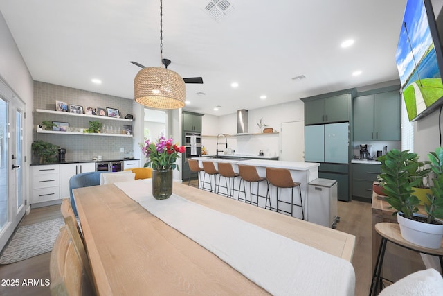 5439 W Odeum Ln, Phoenix, AZ 85043 - dining space with light wood finished floors, wine cooler, ceiling fan, recessed lighting, and bar area