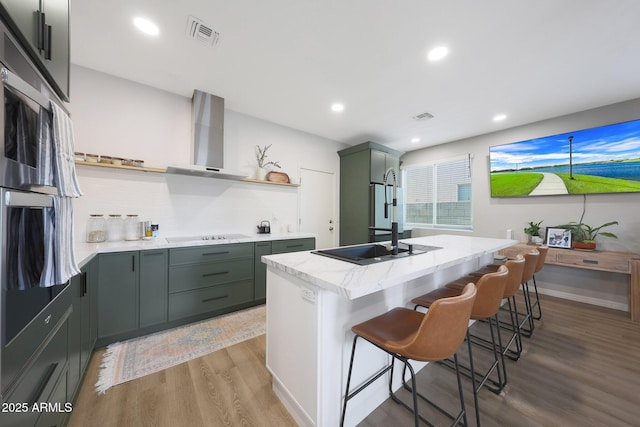 5439 W Odeum Ln, Phoenix, AZ 85043 - kitchen with open shelves, wall chimney range hood, light wood-type flooring, backsplash, and green cabinets