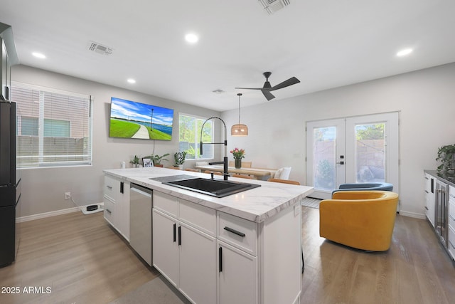 5439 W Odeum Ln, Phoenix, AZ 85043 - kitchen featuring light wood-style floors, stainless steel dishwasher, a center island, a ceiling fan, and french doors