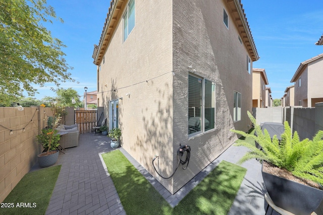 5439 W Odeum Ln, Phoenix, AZ 85043 - view of side of property with stucco siding, a patio area, and a fenced backyard