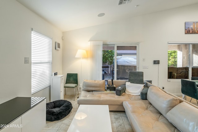 tiled living room with a healthy amount of sunlight and lofted ceiling