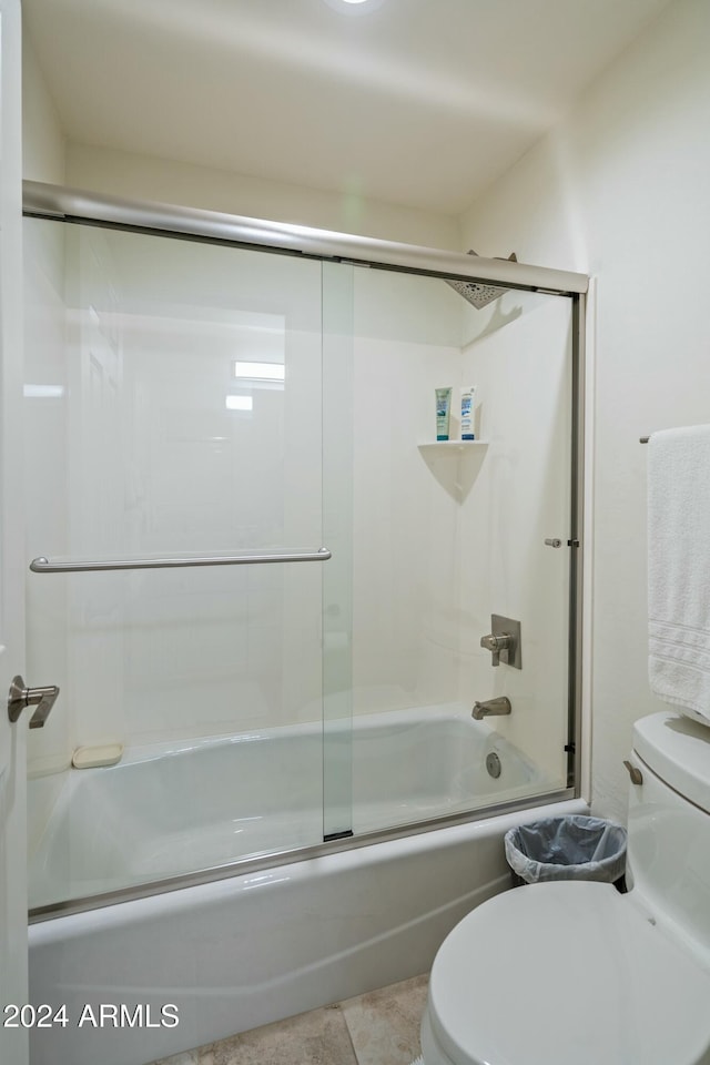 bathroom with tile patterned flooring, toilet, and shower / bath combination with glass door