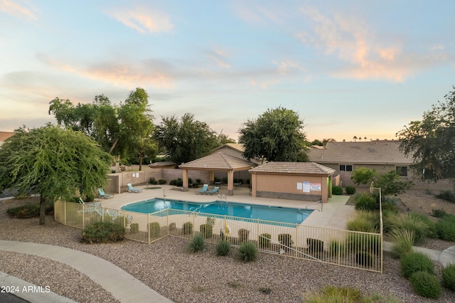 pool at dusk featuring a patio