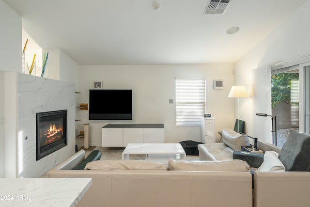 living room with a high end fireplace and lofted ceiling