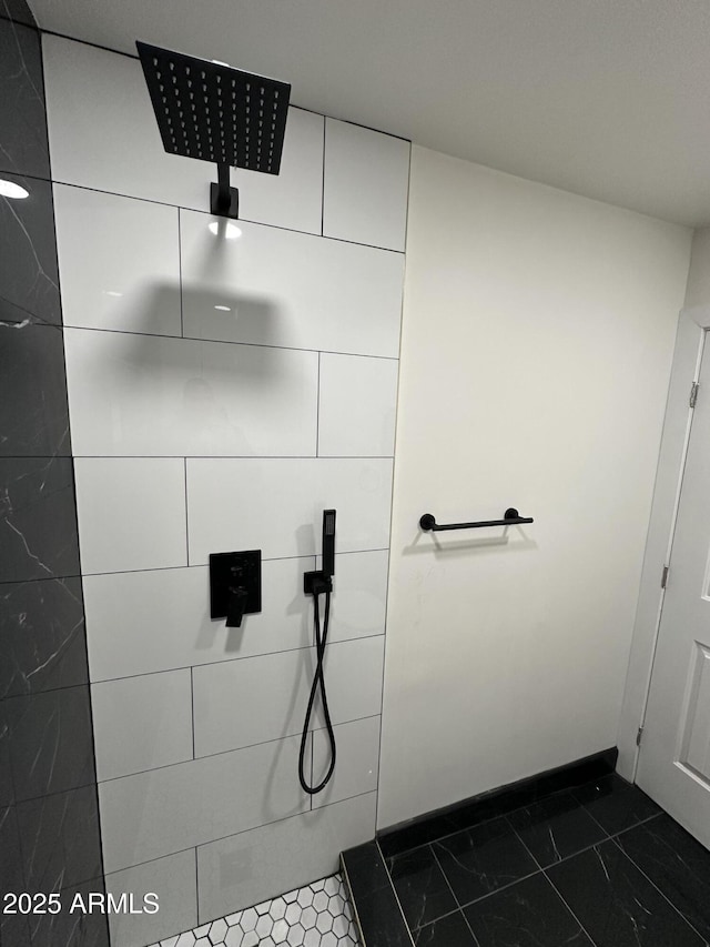 full bathroom with baseboards and a tile shower