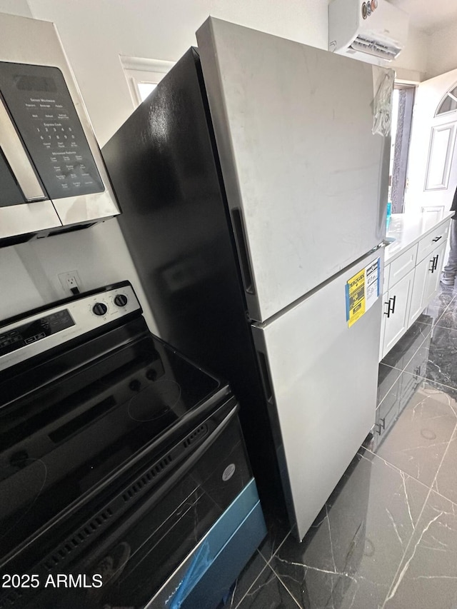 kitchen featuring white cabinetry, marble finish floor, stainless steel appliances, and a wall unit AC
