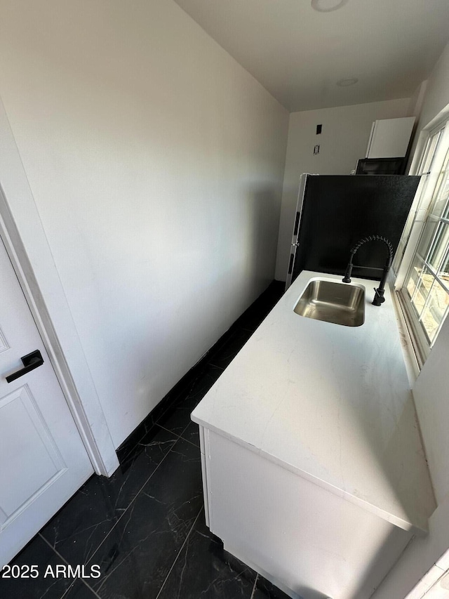 laundry room with marble finish floor and a sink