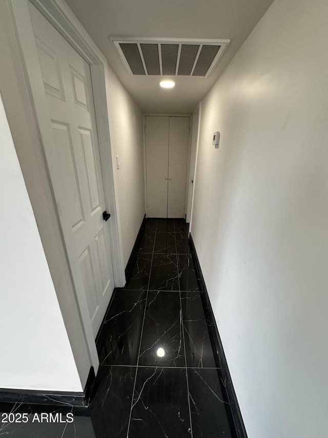 hall with visible vents, marble finish floor, and baseboards