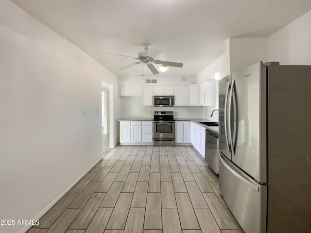 kitchen featuring ceiling fan, sink, white cabinetry, and stainless steel appliances