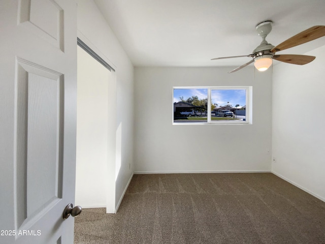 carpeted spare room with ceiling fan