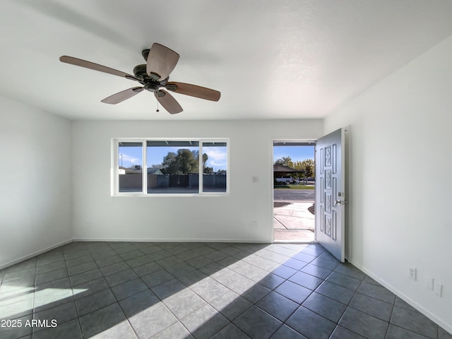 spare room featuring tile patterned floors and ceiling fan