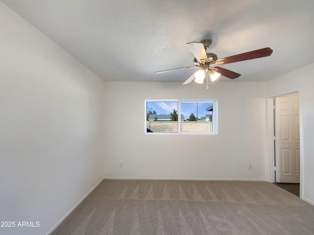 spare room with ceiling fan and carpet