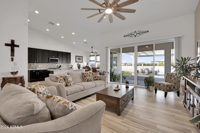 living room with ceiling fan, light wood-type flooring, and high vaulted ceiling