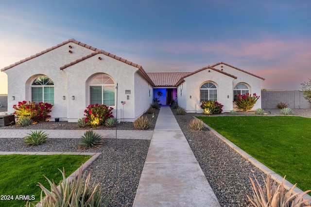 mediterranean / spanish home featuring a yard