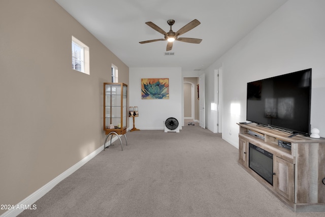 unfurnished living room with light carpet and ceiling fan