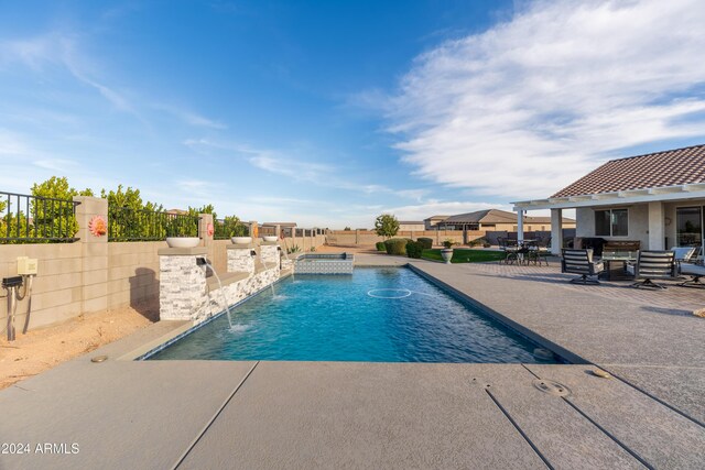 view of pool with pool water feature and a patio