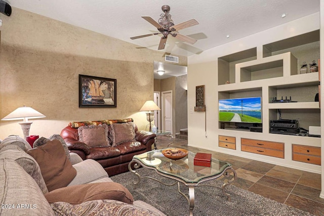 living room with built in shelves, a textured ceiling, and ceiling fan