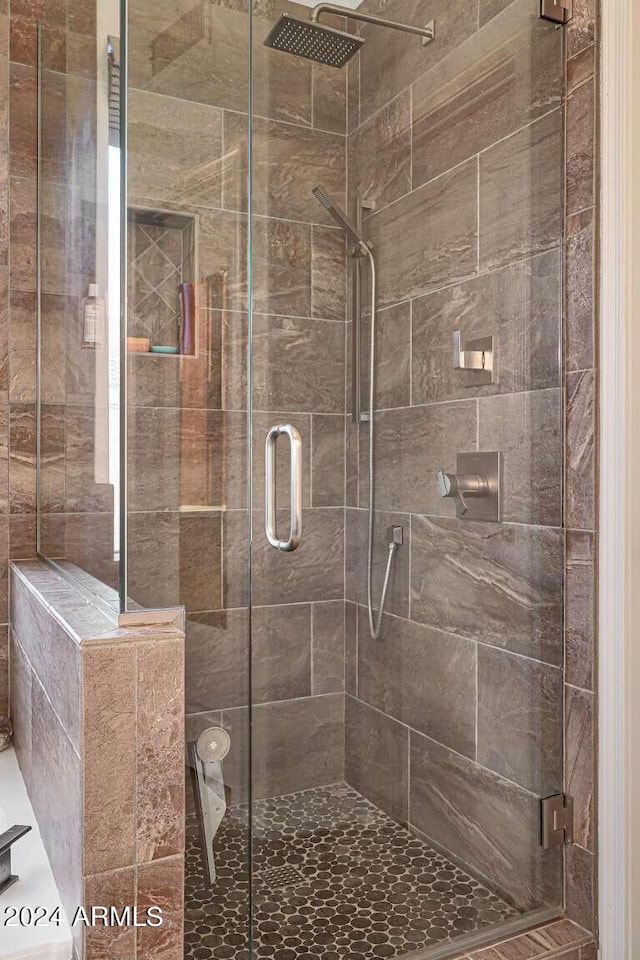 bathroom featuring a shower with door