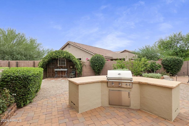 view of patio with area for grilling and a grill